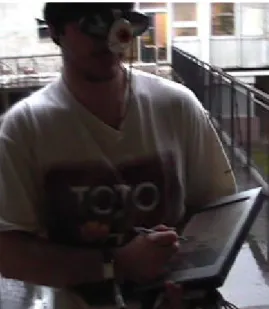 Fig. 2.   A MAGIC user, equipped with the HMD and holding the pen computer.