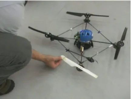 Figure 3-9: Photo of the modified propeller blade (white) with tips removed. The razor blade and servo motor can be seen attached to the quadrotor frame.