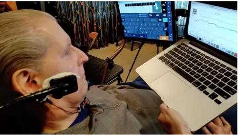 Figure 4-1: One of our primary users pictured above who was already adept at us- us-ing communication technologies as seen with his Eyegaze communication on the left screen.
