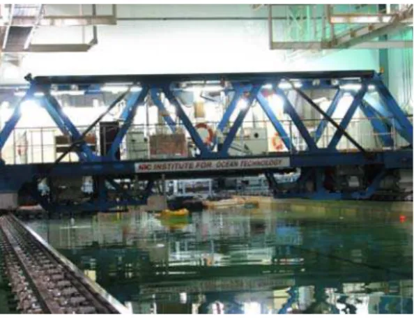 Figure 1: the IOT Ice Tank carriage with the  PMM attached to the Test Frame, with the  yellow model icebreaker attached to the PMM
