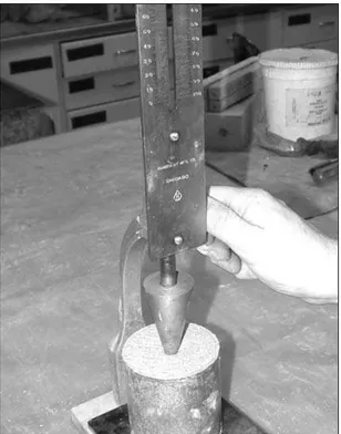 Figure 3. Le cône de Vicat tombe librement  dans un cylindre de mortier; la profondeur de pénétration donne un indice de la consistance  du mortier.
