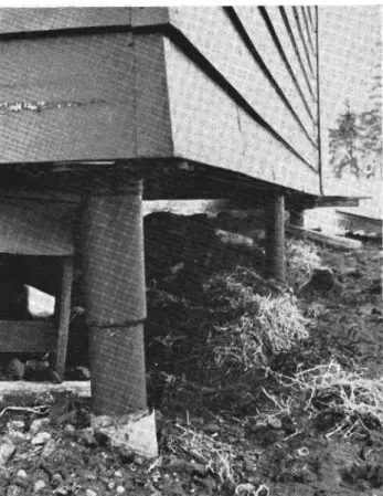 Figure  12.  Pipes supported by  concrete footing  below frost line replace former surface footings on this building.