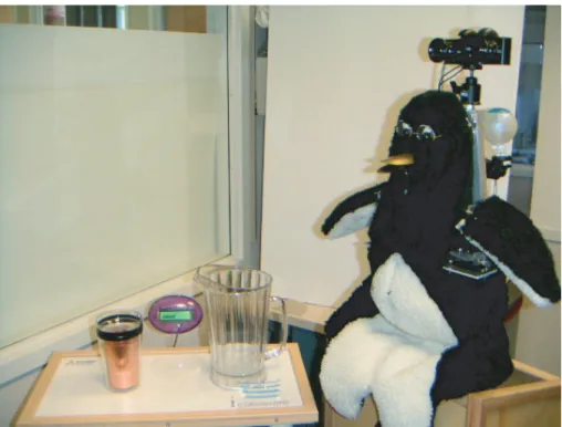 Figure 2-2: Mel, an interactive robot, can present the iGlassware demo (table and copper cup on its right) or talk about its own dialogue and sensorimotor abilities.