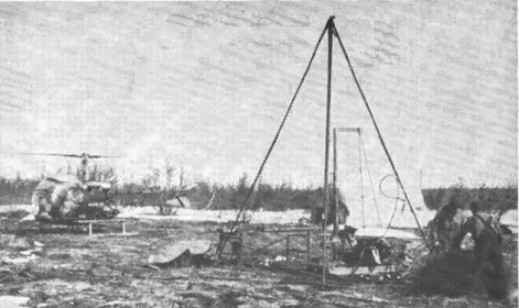 Fig.  5.  Drill  rig  operation before airlift  to  next drilling  location. Tent  in  background provides shelter for  soil sampling and photographing frozen cones.