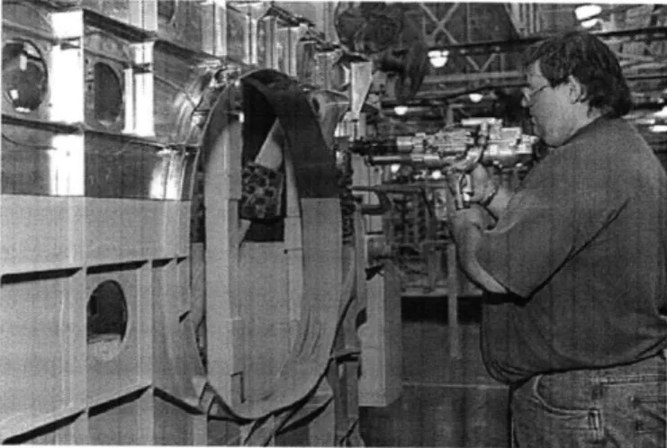 Figure 1:  An assembly  worker  at  an aircraft  manufacturing  plant  attempts  to piece  together  parts  of an  airplane