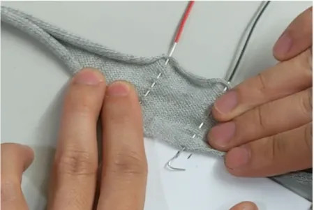 Figure 3-2: A strip of conductive knitted fabric is stretched and probed to observe it’s strain sensing capabilities