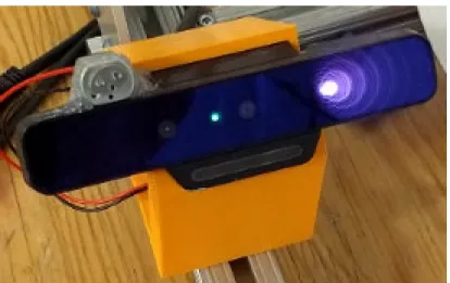 Figure 3-1: Intel SR300 camera. On the face of the camera, from left to right, you can see the SL camera, on-indicator light, RGB camera, and SL projector.