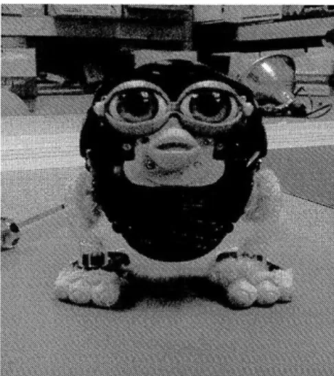 Figure 2:  The  Baby Furby  with the outer  covering  removed.  The  cords  of the  chest sensor  are visible  in  the  front, and  some of the internal  actuation  is visible  through  gaps in the plastic housing.