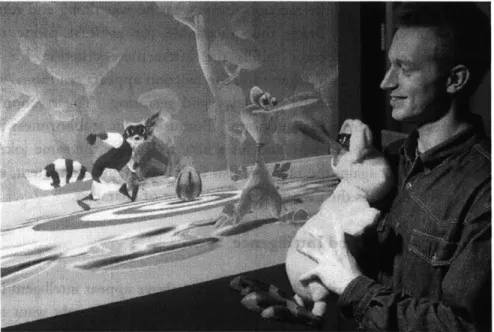Figure  2:  The  author  interacting  with  the  SWAMPED!  demo.  The gestures  registered  by  the  instrumented  plush  toy  direct  the  behavior  of the  chicken