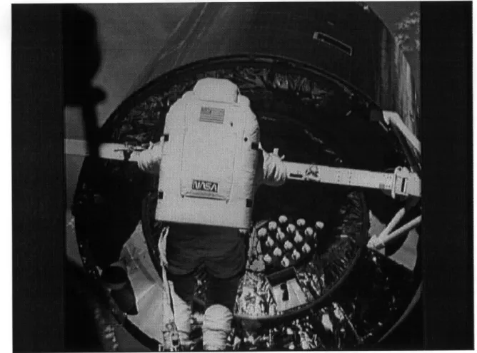 Figure 2.6  Astronaut attempting  to attach capture  bar to  satellite interface  ring