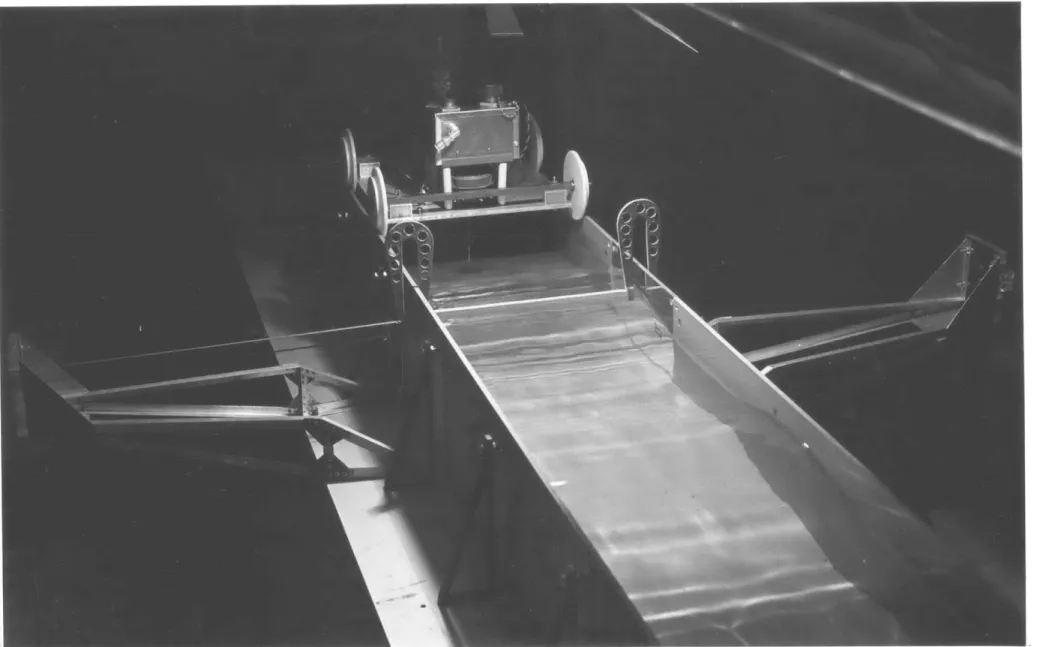 Fig.  4  Overall view of boom in wave  tank showing elastic  constraint support  arms  and capacitance wave height guage  (on carriage  behind  the boom model).