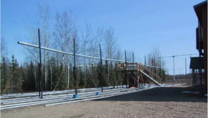 Fig. 1. Photograph (April 2003) of the 2.85-MHz (18-cm diameter – 5200 cm long) Hertzian antenna at HIPAS, suspended from  in-sulating 10-cm diameter ABS drainpipes, 500 cm above a ground plane made up of 6.4-cm diameter aluminum pipes