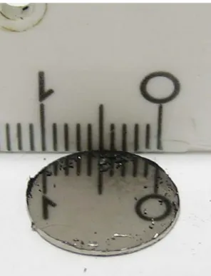 Figure 5. Bulk pill pressed from bismuth nanopowder pressed uniaxially at 370 MPa. The nanocrystalline metal is highly reﬂecting as can be seen from the mirror image of the white ruler (cm scale).