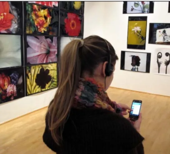Figure 6. A visitor using the catalogue on iPhone as interactive guide at the  Araki exhibition 