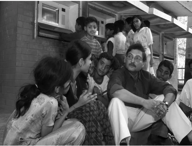 Figure 2.2: Sugata Mitra and a Group of Children Next to Wall Computers in India 