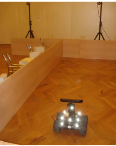 Figure 4.3: Wifibot robot in its testing arena, surrounded by Optitrack cameras