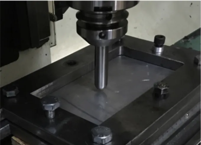 Fig. 1. A straight groove test specimen clamped below the hemispherical head tool.