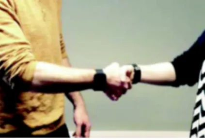 Figure 2 Two people shaking hands  using smartwatches.