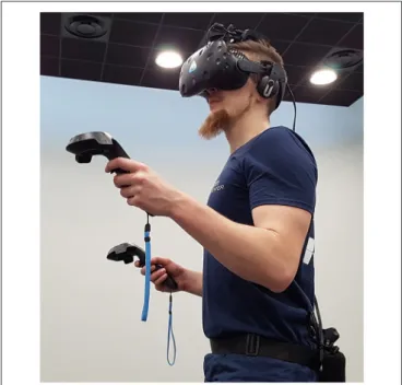 FIGURE 4 | User equipped with the required devices for the experiment: HTC Vive virtual reality headset, Vive trackers, TP Cast wireless adapter