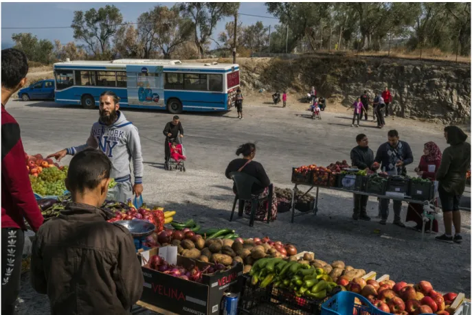 Figure 6.  Étals de fruits et légumes et autobus autour du camp de Moria. Photographie  de Mauricio Lima pour le New York Times (Lima 2018) 
