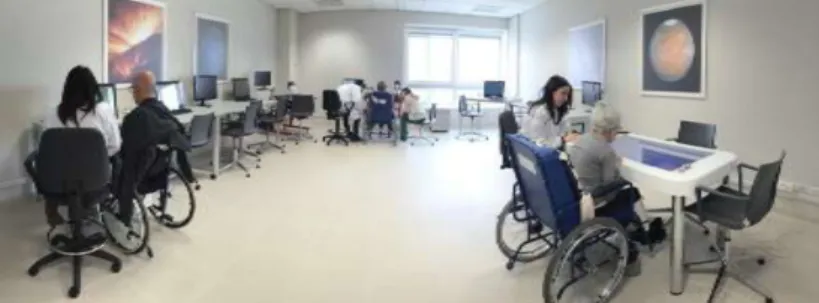 Figure  4:    A  patient  during  a  BCI  session  with  the  Promotœr  (centre  of  the  picture)  in  a  room  dedicated to technologically supported motor and cognitive rehabilitation at Fondazione Santa Lucia