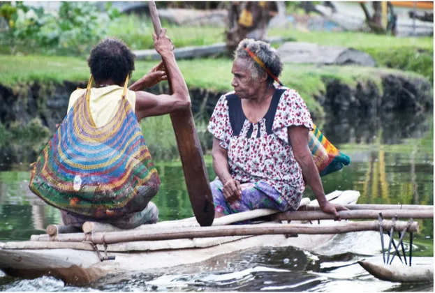 Figure 4: Tufi women with bilums paddle to the market (© Jan Hasselberg)