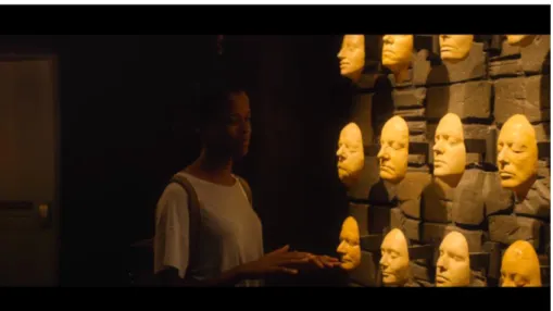 Fig. 5 Nish Leigh (Letitia Wright), la “visitatrice” del Museo Nero, di fronte alle  maschere dei criminali protagonisti degli episodi di Black Mirror