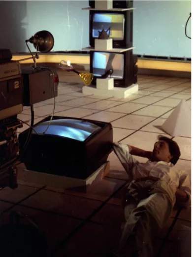 Fig. 1 Carlo Massarini nello studio di Mister Fantasy, marzo 1983. Sono visibili due opere  del videoambiente di Studio Azzurro, Luci d’inganni, 1982