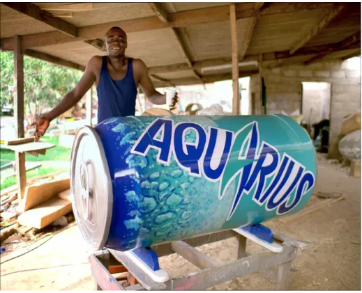 Fig. 1 Eric Adjetey Anang e la sua creazione Aquarius cofn durante le riprese   pubblicitarie della bibita omonima