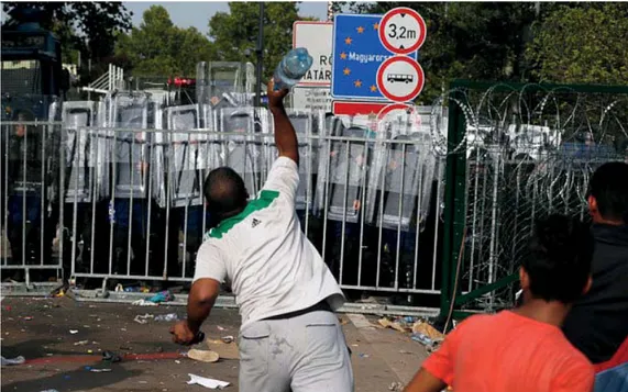 Figure 3. Telegraph, © AP, with caption: “A refugee throws a bottle toward Hungarian police at the ‘Horgos  2’ border crossing into Hungary, near Horgos, Serbia”