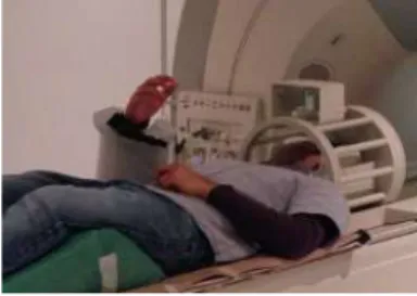 Fig. 4. The experimental fMRI setup:The subject is using MRI compatible finger inside the fMRI scanner.