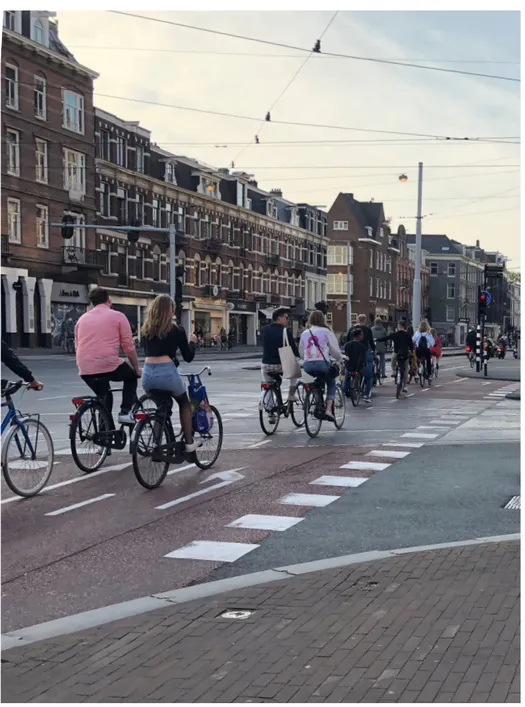 Fig. 3 · Ciclisti attraversano la strada ad Amsterdam, 2018.