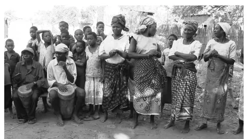 Figure  6.  The  basic  clapping  on  the  beat  by  the  women  coincides  with  a  stroke of the left hand of the mbandambanda drummer seen on the left