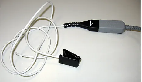 Figure 3.15: Nonin Xpod – La scatola grigia contiene l'elettronica per  l'elaborazione del segnale, mentre a sinistra vediamo la clip – sensore.