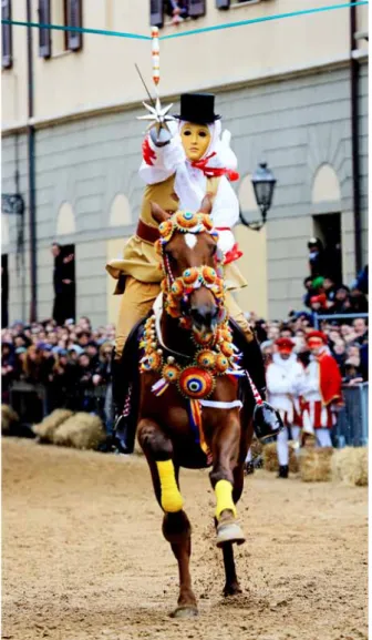 Figure 1. The masked horsemen at a gallop during the attempt to  run a sword through a hole in a suspended silver star (courtesy of Sartiglia  Foundation archives).