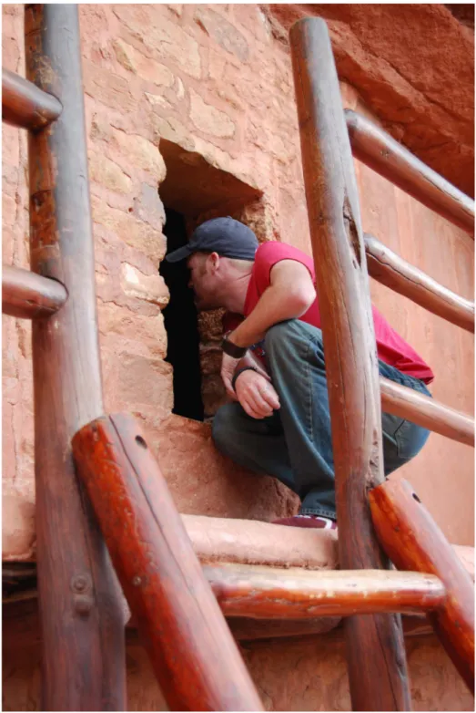 Fig. 6. A tourist looking inside one of the windows on the second story of the Manitou Cliff  Dwelling (photograph by author, 2013) 
