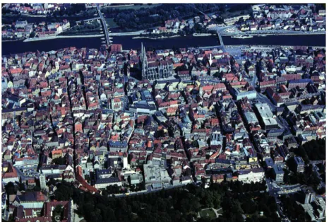 Abb. 1a. Luftbild der Regensburger Altstadt. Deutlich zeichnen sich der  Verlauf der römischen Lagermauer und die Lagerhauptstraßen ab (Pfeil: 