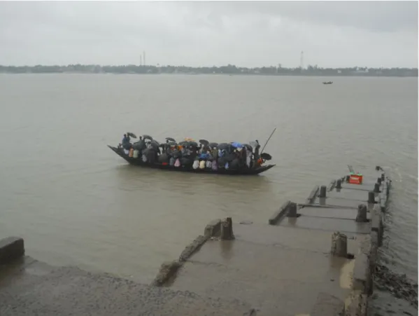 Figure 3: Commuters approach Godkhali ghat during rains. Note the umbrellas covering the entire  boat