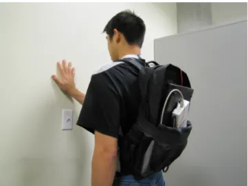 Figure 1: Participant performing a touch gesture above a light switch. The signal is measured at the  partici-pant’s neck and than recorded by the data acquisition unit and a laptop in the bagpack