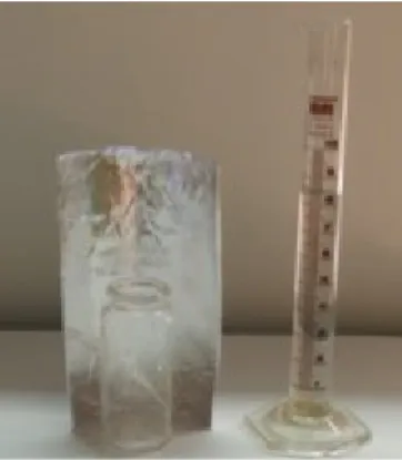 Abbildung 2: Ein mit Wasser gefülltes Schnappdeckelglas wird vor dem gebastelten Parabolspiegel  positioniert und angestrahlt