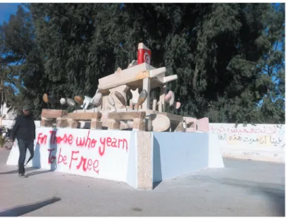 Abbildung 3 :  Provisorisches Denkmal zur Erinnerung an Bouazizis  Verkaufsstand in Sidi Bouzid  ( Quelle :  Volker Wulf ,  Januar 2012 )  Der Aufstand in Sidi Bouzid wird datiert auf die Zeit vom  17