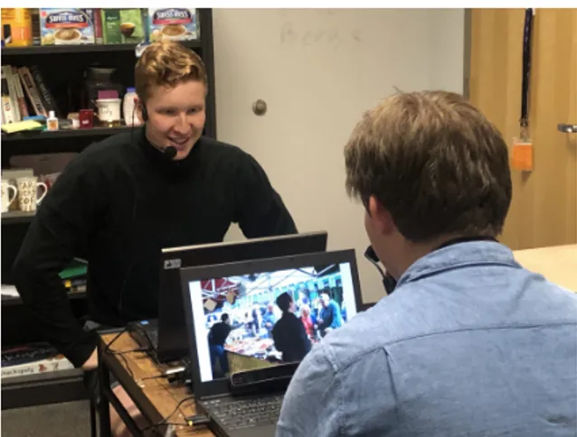 Figure 3: Experiment set-up: Two interlocutors seated across each other with their respective microphones, eye trackers and laptops.