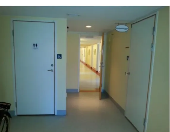 Figur 11. Vy från mitten av kapprummet mot korridoren. Mötesrummet är innanför dörren  till höger i bilden