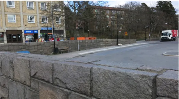 Figur	11:	Vy	över	den	ena	busshållplatsen	vid	busstorget.	Den	höga	muren	runt	busstorget	skapar	en	barriär.		Foto	av	 Sophie	Linderoth		