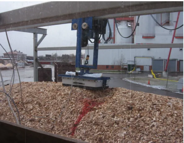 Figure 3.3: Picture of the full-scale measurements. The GPR antenna is placed on the surface of woodchips inside a transport container at a combined heat and power plant.
