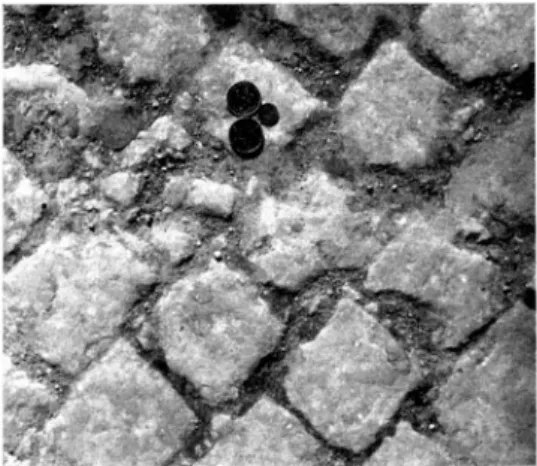 Fig.  13.  Smågatsten,  de  i  cementbruk  satta  stenarna  utsättas  för  krossning.  25