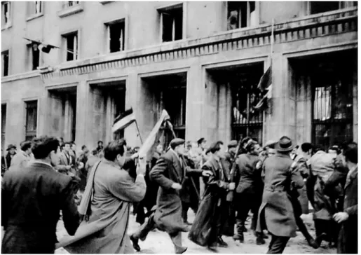 1. kép. John Sadovy sálban közepén, kamerával a kezében fut a pártszékház előtt,  a Köztársaság téren
