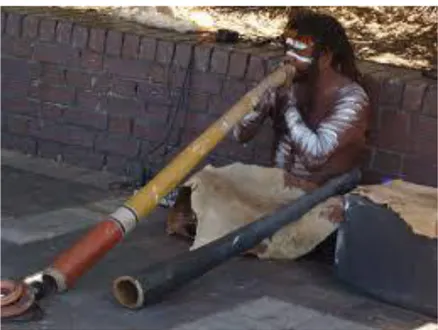 Şekil 3. Sidney’de Didgeridu çalan yerli insan (http://www.musicwithease.com).  Gılgamış  destanında  da  rastlanılan  içi  oyulmuş  ağaç  kabuklarından  üretilen  çalgının  trompetin buluşuna ışık tutan sağlam bulgular oldukları düşünülmektedir