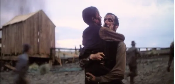 Figure 3. Daniel (Daniel Day-Lewis) carries H.W. (Dillion Freasier) to the mess room after a  massive oil burst 