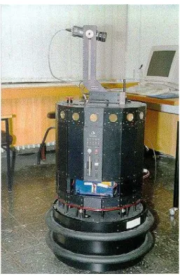 Figure 2. Nomad 200 mobile robot. The ring of ultrasonic sensors can be seen close to the top rim of the turret, and the structured-light laser system is seen pointing rightwards on top.